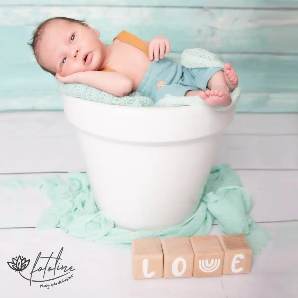 Photo d'un bébé qui dort avec une décoration Alphacubes de Louyou en 4 cubes et stickers blanc