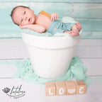 Photo d'un bébé qui dort avec une décoration Alphacubes de Louyou en 4 cubes et stickers blanc